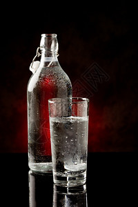 生活黑色玻璃桌上的水杯和瓶子相照片凝结杯子图片