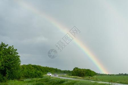 在暴风的黑暗天空中彩虹在一条路上光谱阿尔比娜象征图片