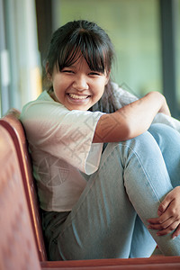 幸福坐在木椅上的亚裔青少年笑脸松弛喜悦图片