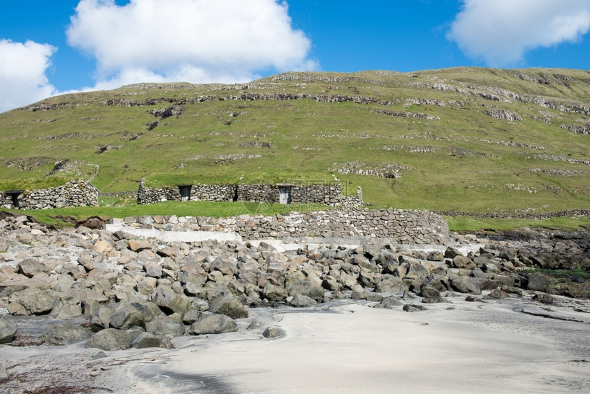 法罗群岛的典型风景绿草和石块典型的海洋岩石图片