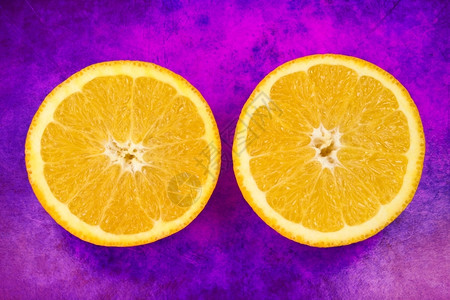 充满活力红紫背景的新鲜橙子水果将两分之一半节食明亮的图片