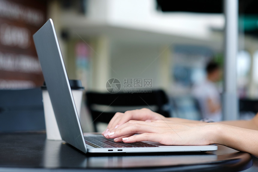 随意的移动数字在户外咖啡店使用膝上型计算机的妇女手背景人与技术生活方式图片
