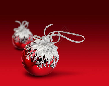 两个圣诞球雪花装饰生红色背景2个圣诞球红黑色背景闪耀模糊亮的背景图片