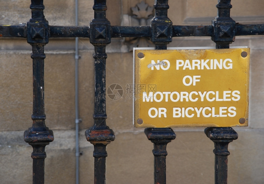 禁止的黄色停泊摩托车或自行不得挂在金属围栏上的牌绞刑图片