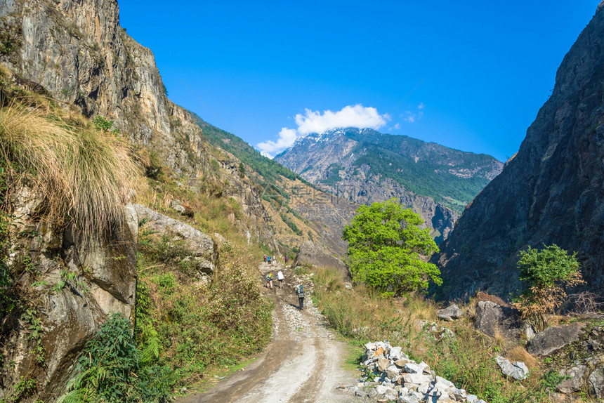 岩石游客天空喜马拉雅山上一条路的旅游者在尼泊尔安纳普附近旅行图片