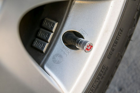 微笑安全合金检查轮胎压力将空气泵入汽车轮式机的气压图片