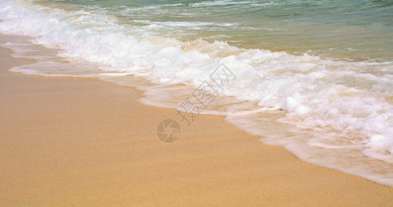 质地关闭金沙滩和海浪的绿水热滩背景图片