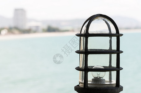 旅行海浪滩洋附近高山一角的老旧金属灯台背景图片