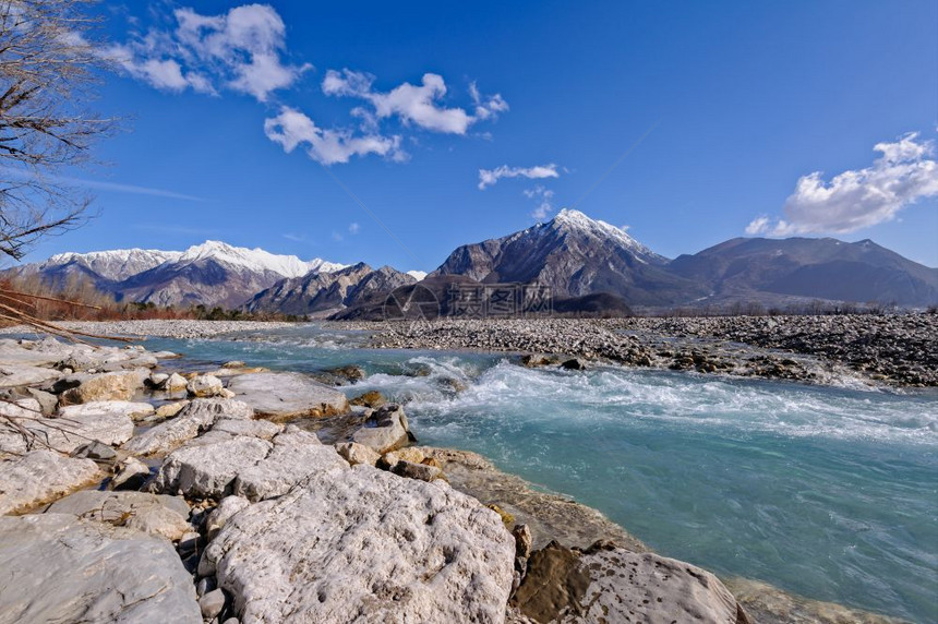 美丽的水树山地景观河流岩石和瀑布对着蓝天图片