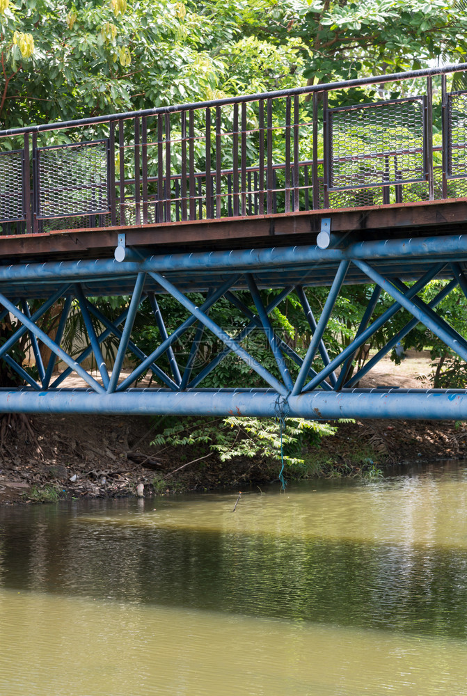 城市的现代木桥和金属架的子正在穿过运河到城市公园水旅行图片