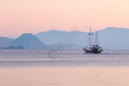 游客开往希腊科斯克港黎明时启航至远处海伦水图片