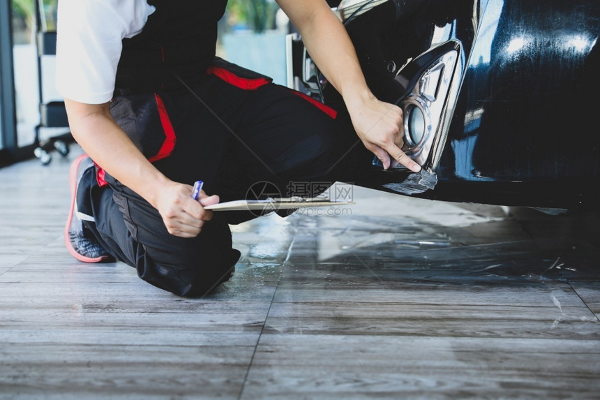 剪贴板宣称服务保险公司检查汽车损坏时面油漆刮痕的工人保险公司检查车辆损坏情况图片