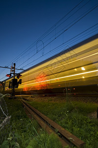 栅栏速度一列全火车在黄昏经过铁路境点穿越图片