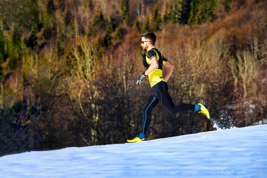 男人公园一名年轻男子运动员在雪中跑步户外图片
