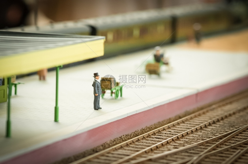 身穿衣装的男子等待火车微型模浅Dof孤独为了车站图片