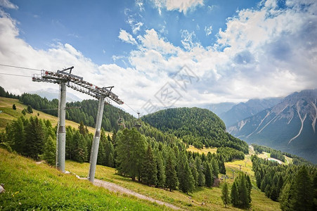 山地全景森林多洛米人山谷和夏季椅子升起乡村的云图片