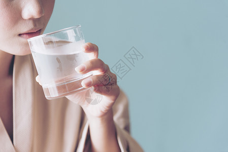 美丽的女人喝着新鲜的冷水重整洁皮肤环境渴干净的背景图片