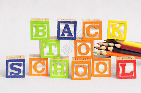 多彩块艺术工具回到学校后以字母块拼写用黑色背景的彩铅笔显示后退背景