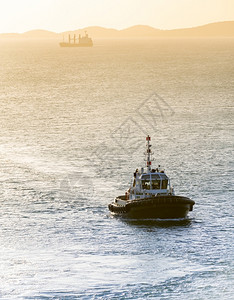 海洋血管日落光下拖船返回港湾图片