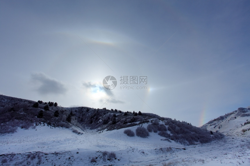 天太阳的哈索特在俄罗斯北高加索的Hasaut村山上冬季日晒太阳周围的大光环绕着太阳图片