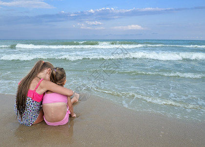 姐妹坐在沙滩上看海图片