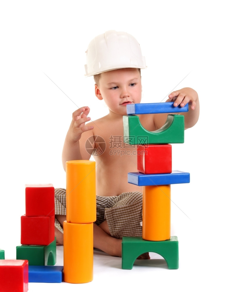 年轻的小男孩在白色背景上盖了一栋玩具屋快乐的美丽图片
