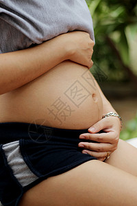 年轻的关心孕妇把爱送到婴儿身边产假背景图片