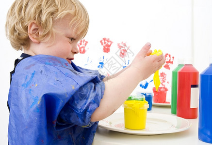 男生涂抹小孩用一根手指涂漆把浸在锅里花盆图片