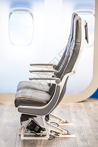 关闭停在木制地板上的飞机座椅旅游航班窗户图片