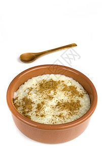 自己制的米饭牛奶和肉桂在一块陶瓷碗中孤立在白色上西班牙语香草料图片