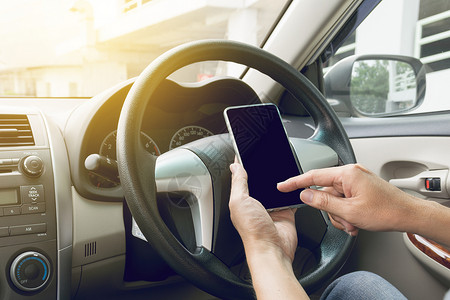 互联网驾驶汽车和使用移动电话的男子展示技术图片