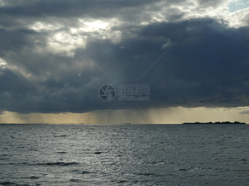 一种气旋龙卷风巨大的黑云在海中倾盆雨云景图片