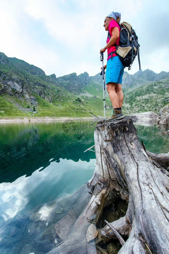 攀登山湖里一个干枯的树桩上女人远足者最佳悬崖图片
