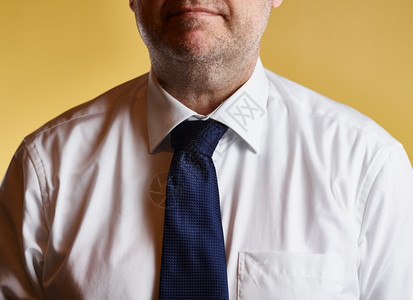 棉布穿着白衬衫蓝色领带黄背景的男身着白衬衫和蓝领带色的白图片
