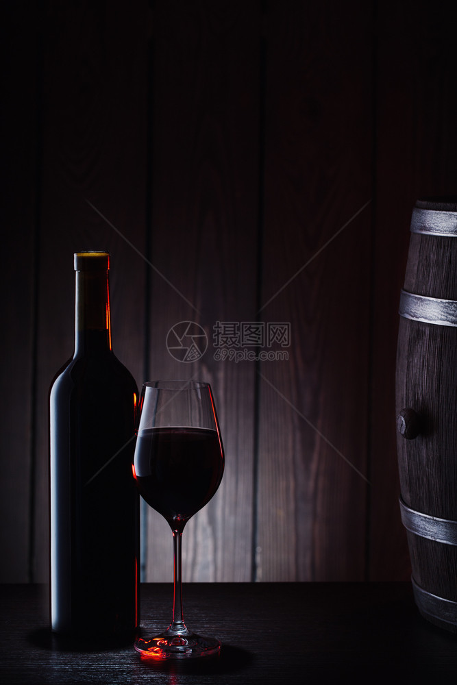 喝液体反射酒瓶和一杯红以桶板为背景酒瓶和一杯红以桶板为背景图片