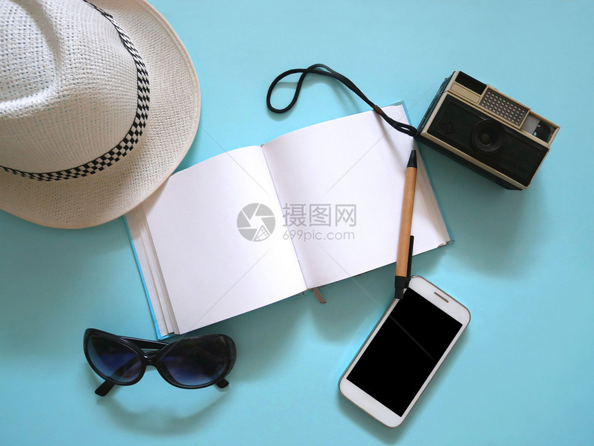 放旅游夏天行附件帽子反光照相机太阳镜和带蓝色背景影印空间的电话图片