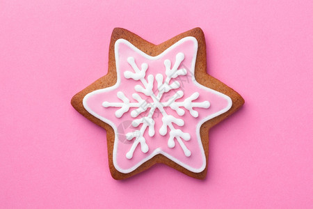 粉色的美丽圣诞节姜饼明星干粉红背景的雪花上加自制生姜图片