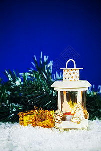 前夕烛光在蓝色背景下配有礼物的圣诞灯笼展示图片
