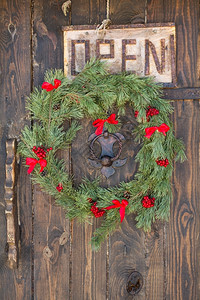 圣诞门环木门上的圣诞花圈弓球丝带背景