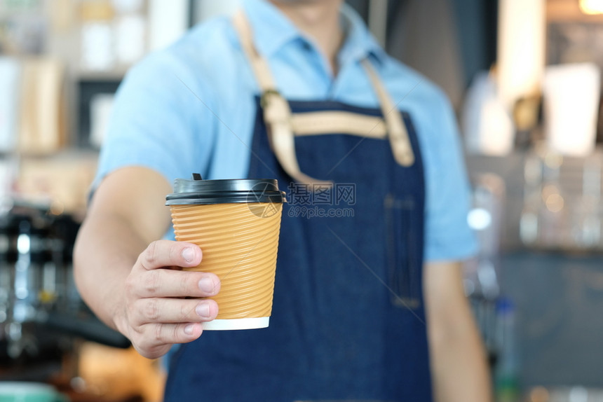 在咖啡馆柜台背景小商业主食品和饮料业举行咖啡杯的酒吧男手持咖啡杯服务行业年轻的图片