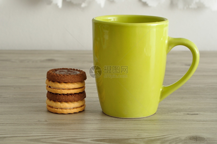 绿色咖啡杯加一堆圆饼干木头白色的热图片