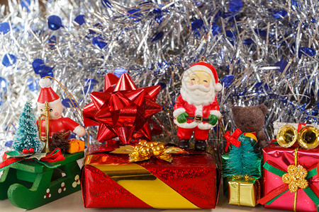 假期花环圣诞老人雕像配有礼品和蓝银色锡罐作为圣诞节的装饰品礼物图片