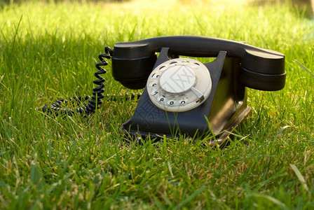 老的座机在草地上重型旋转电话连接图片