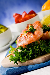 串烧地中海鱼生菜床上美味烤虾的照片蓝底肉桂蛋白尼图片