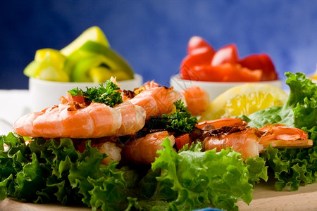 胡椒烹饪生菜床上美味烤虾的照片蓝底肉桂蛋白尼绿色图片