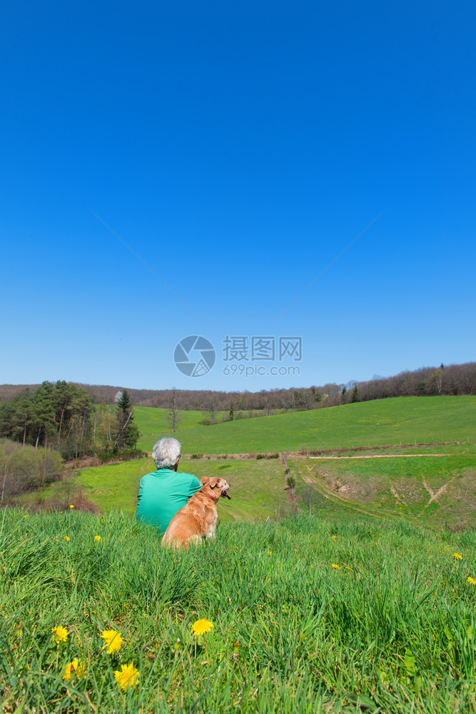 坐着法语男人和狗坐在法国风景中棕色的图片