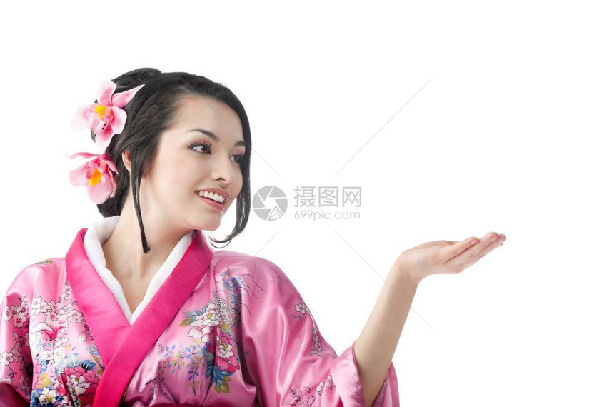 问候日本年轻女在白背景上穿传统喜莫诺服装和展示什么的肖像日本年轻女人们粉色的图片