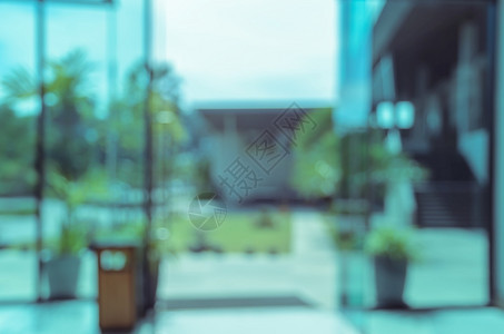注意力分散建筑学入口花园玻璃窗的模糊抽象背景有开放门办公室或酒店大楼视图在窗户上背景