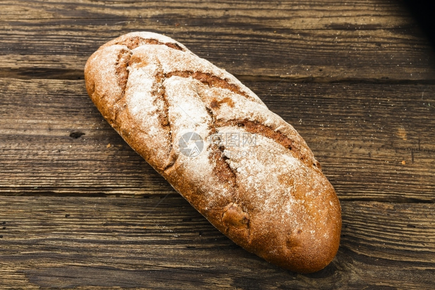 法国面包脆皮谷物黑暗背景上的新鲜白面包图片