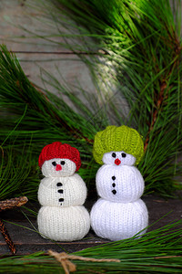 绿色2个圣诞雪人来自编织玩具站在松树前面假期惊人的图片